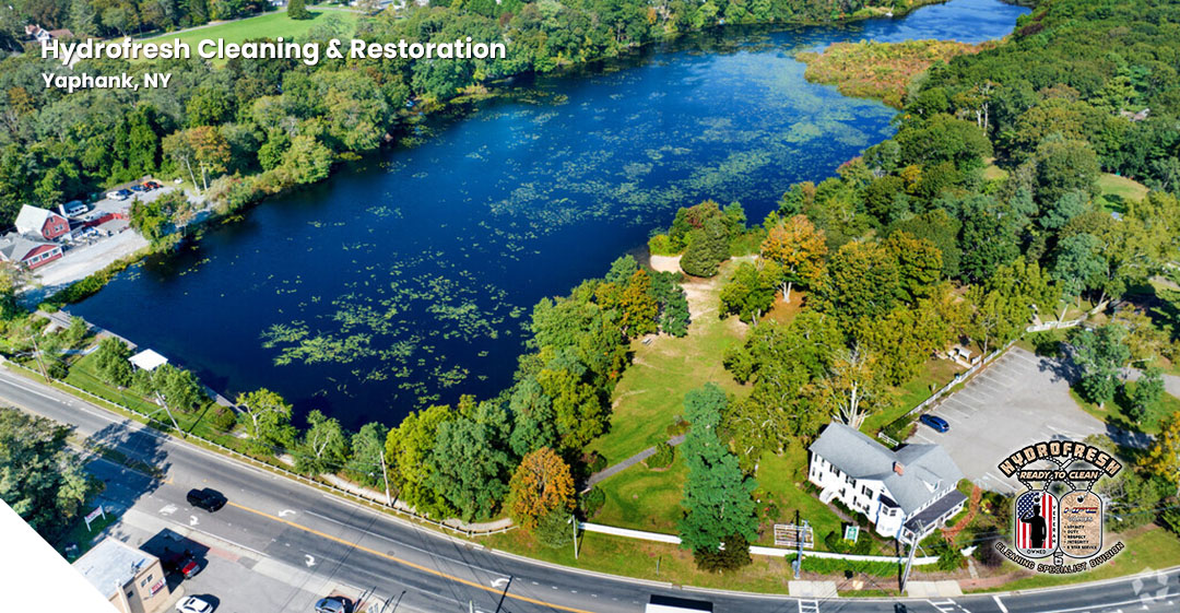 A serene stretch of Carman's River, reflecting the surrounding trees under a clear blue sky.